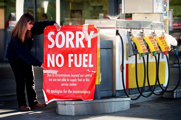 Garage worker Nicole Tuxford puts up a sign at a Shell petrol station in Dunblane
